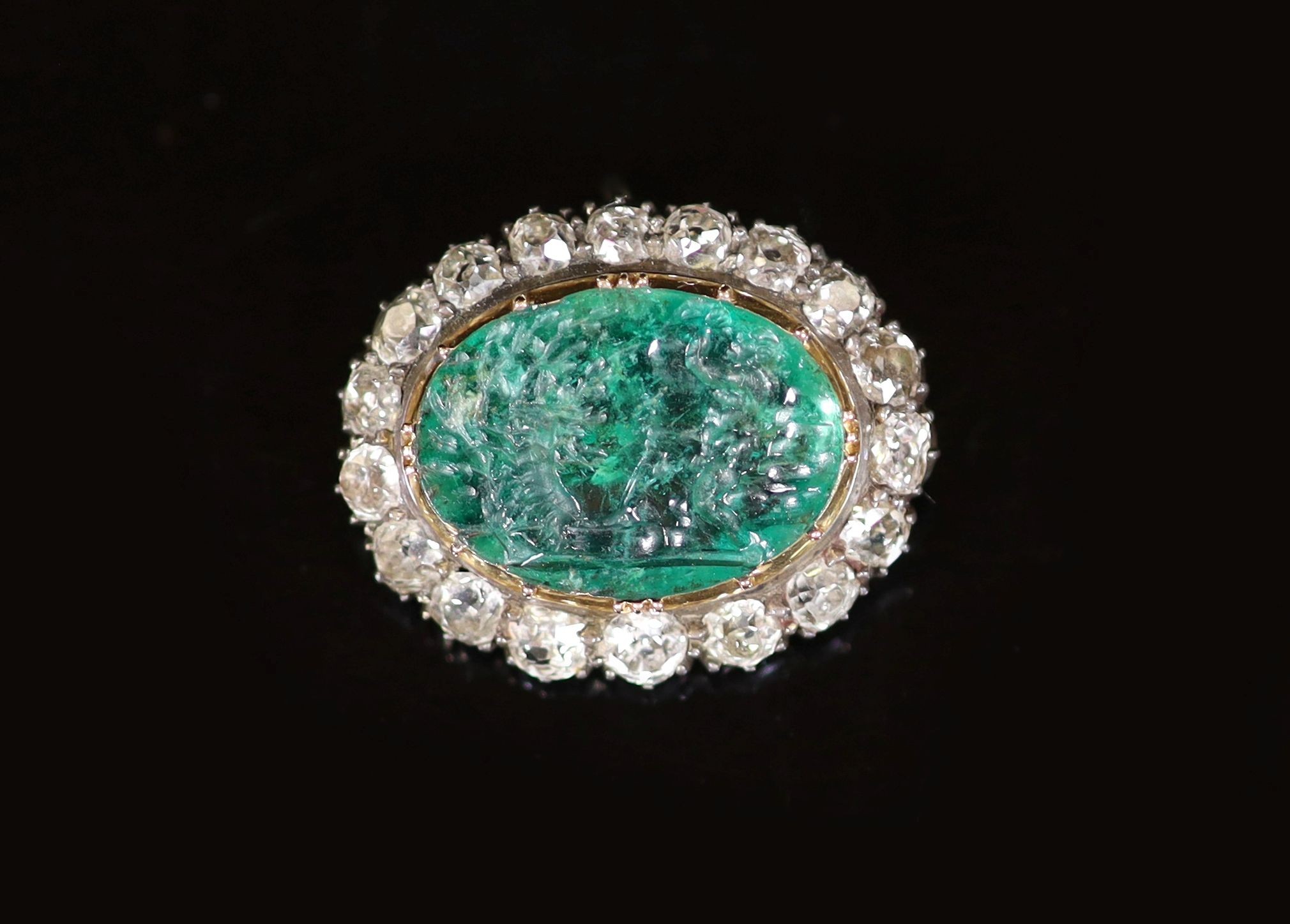 A possibly Roman oval intaglio emerald, mounted in an early Victorian gold, silver and diamond set oval pendant brooch